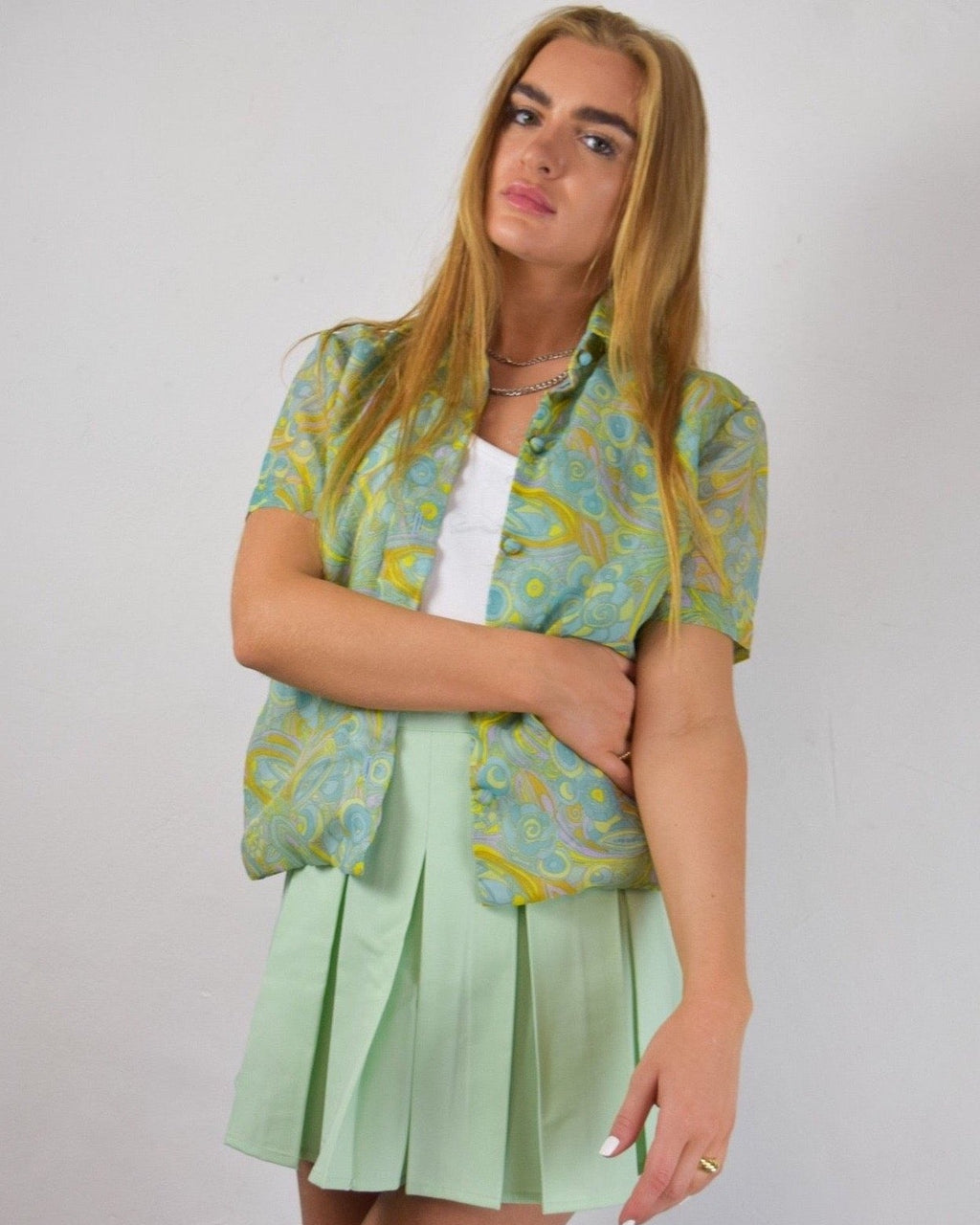 girl in paisley print shirt with white nails 