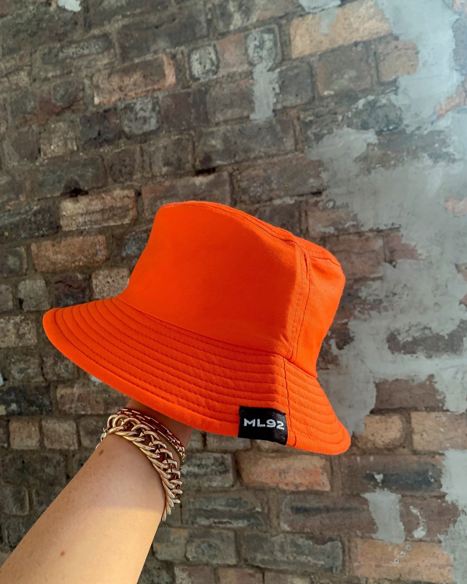 Orange bucket hat with ML92 tab on rim